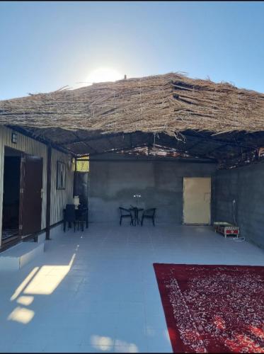 Duży pokój z dachem ze stołami i dywanem w obiekcie نزل ريفي w mieście Madain Saleh