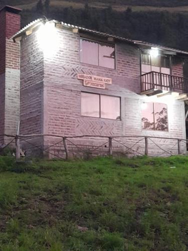 ein Backsteingebäude mit einem Schild in der Nacht in der Unterkunft Mamá Naty y sus Neguitos in Chambo