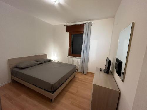 a bedroom with a bed and a television and a mirror at Clodia Skyline in Chioggia