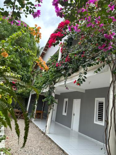 a house with flowers on the side of it at Mar de Gente Pousada in Praia de Moitas