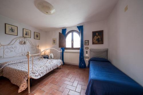 1 dormitorio con 2 camas y ventana en Agriturismo Casetta, en Gavorrano
