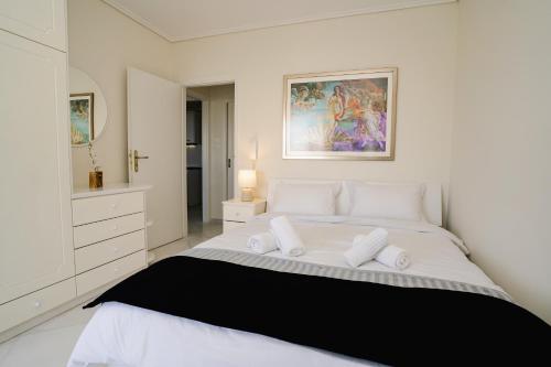 um quarto branco com uma grande cama branca e 2 almofadas em Blue vibes by Glyfada beach em Atenas
