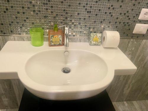 a white bathroom sink with a green cup on it at Albero Mago in Florence