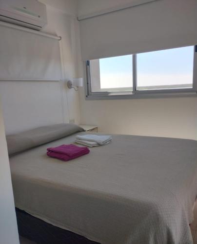 um quarto com uma cama com uma toalha roxa em Departamento San Martin em Buenos Aires