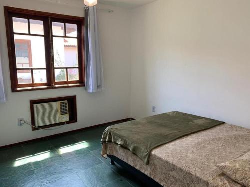 ein weißes Zimmer mit einem Bett und einem Fenster in der Unterkunft Hospede-se em uma fabulosa casa de temporada em Búzios com 03 quartos! in Búzios