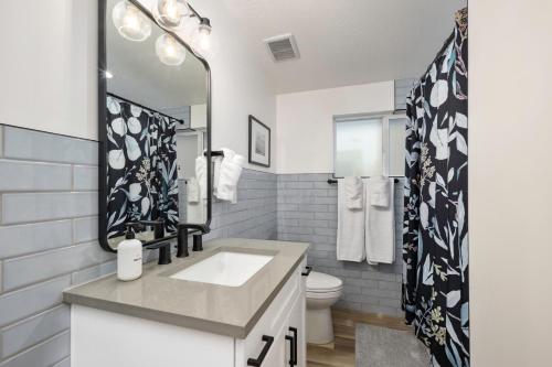 Baño blanco con lavabo y espejo en Renovated Flat near Historic 25th Street, 2BR 1BA, en Ogden