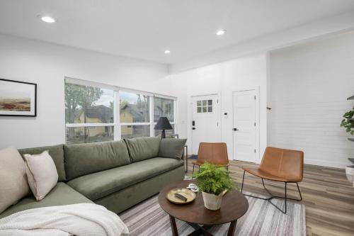 a living room with a green couch and a table at Updated 2BR 1BA Flat Steps from 25th Street Fun in Ogden
