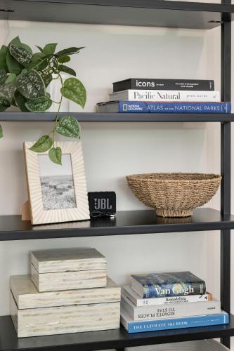 a book shelf with books and a plant on it at Updated 2BR 1BA Flat Steps from 25th Street Fun in Ogden