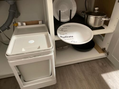 a kitchen cabinet with a white plate and a sink at Sky Studio Apartment 1,5 Zimmer für 4 Leute Zentral 35qm S-Bahn Mercedes Benz in Magstadt