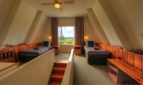 a room with two beds and a window at A-Frame Chalets @ Mokutu in Burnt Pine