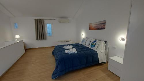 a bedroom with a bed with a blue blanket at Marina House in Cefalù