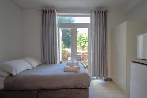 Un dormitorio con una cama con un osito de peluche. en Double Modern Studio London, en Londres