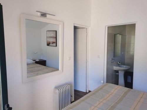 una camera da letto con specchio, letto e lavandino di T1 na Casa da Quinta S José a Praia de Mira