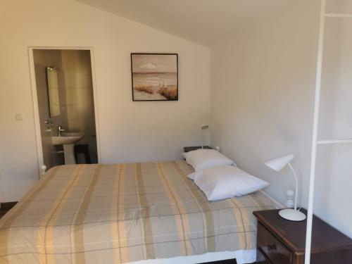 um quarto com uma cama, um lavatório e um espelho em T1 na Casa da Quinta S José na Praia de Mira