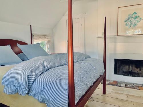 a bedroom with a canopy bed with a fireplace at Marston House Wiscasset in Wiscasset