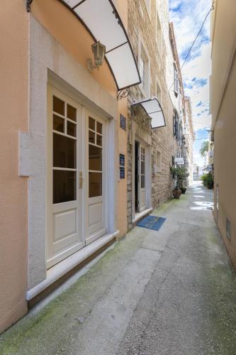 an alley with a white door on a building at Villa Fontana in Trogir