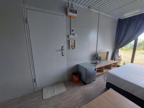 a bedroom with a bed and a door with a desk at SF Homestay in Kundasang