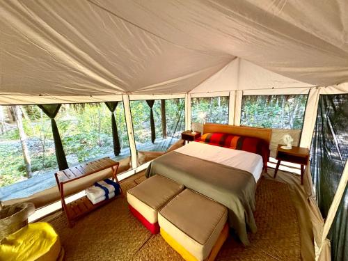 ein Schlafzimmer mit einem Bett in einem Zelt in der Unterkunft Glamping Bunga Lotus in Tulum