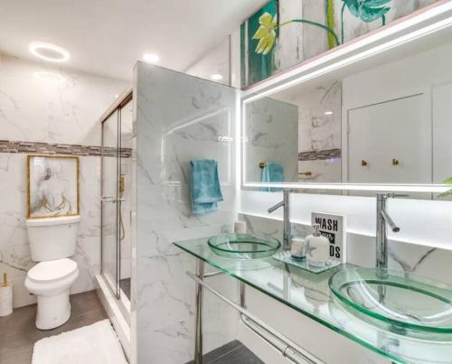a bathroom with two glass sinks and a toilet at Beach getaway paradise in Fort Pierce