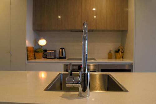 um lavatório de cozinha com uma torneira no balcão em Governor Place - Executive Central Apartment em Kingston 