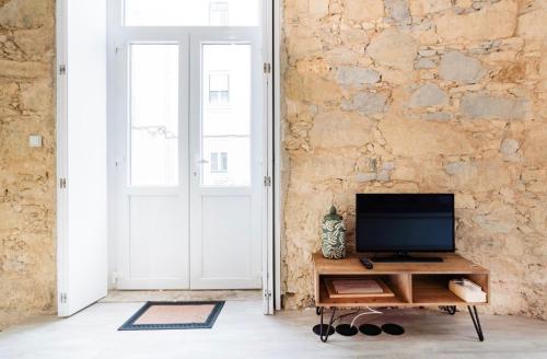 een woonkamer met een televisie op een houten tafel bij LISBON VINTAGE LOFT in Lissabon