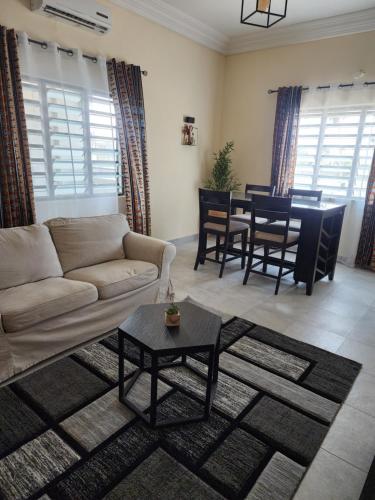 - un salon avec un canapé et une table dans l'établissement Home away from Home, à Cococodji
