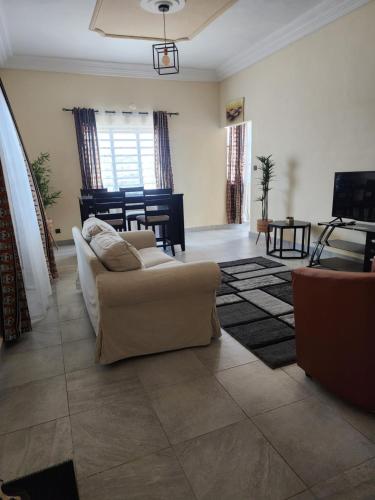 een woonkamer met een bank en een tafel bij Home away from Home in Cococodji