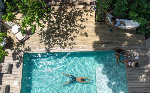 two people are swimming in a swimming pool at Pousada Fruta Pão in Barra Grande