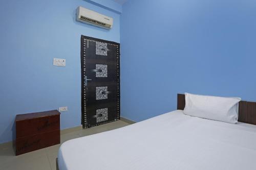 a bedroom with two beds and a blue wall at OYO HOTEL RELAX in Ballabgarh