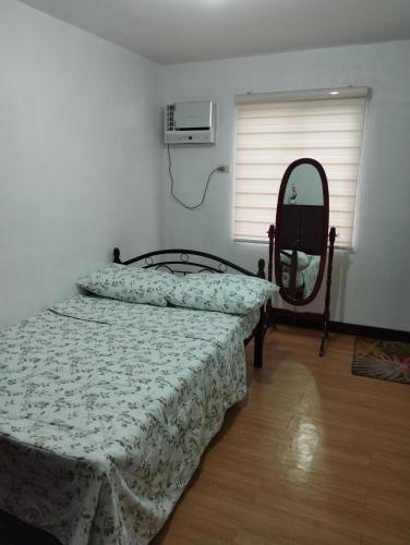 um quarto com uma cama e um espelho em Drea Staycation 2 Bedroom at Urban Deca Homes Marilao em Marilao