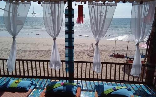 uma vista para a praia a partir de uma varanda em lanta white sand beach guesthouse em Ban Mo Nae