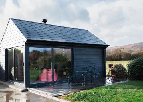 a black shed with a table and chairs at West Cork Way in Bantry