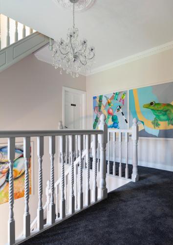 a white staircase in a home with a chandelier at West Cork Way in Bantry