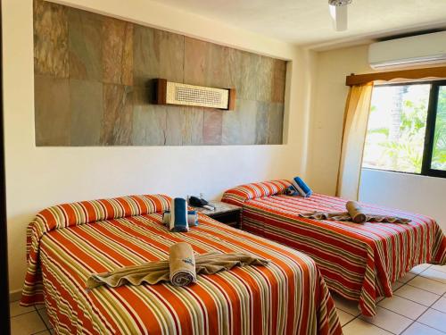 two beds sitting next to each other in a room at Hotel y Villas Quinta Minas in Los Ayala