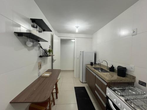 a kitchen with a wooden table and a counter top at Village blue AC Wi-Fi piscina in Cabo Frio