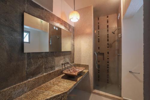 y baño con lavabo, espejo y ducha. en Hotel y Villas Quinta Minas, en Los Ayala