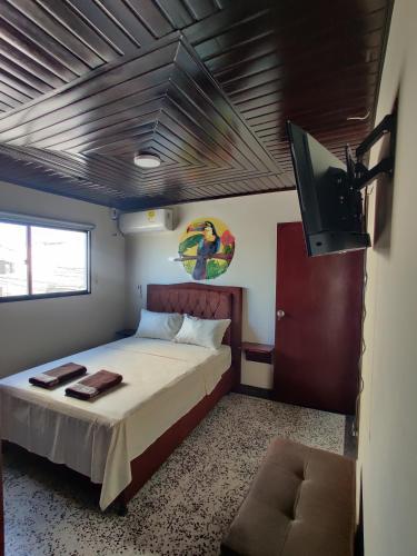um quarto com uma cama e uma televisão de ecrã plano em Hotel - La Perla Del Caribe em Ríohacha