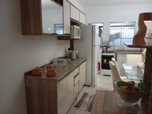 a kitchen with a refrigerator and a bowl of fruit on the counter at Praia Guaibim in Guaibim