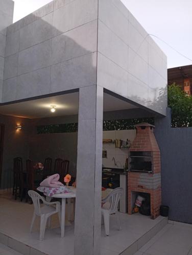 a patio with a table and a brick fireplace at Praia Guaibim in Guaibim