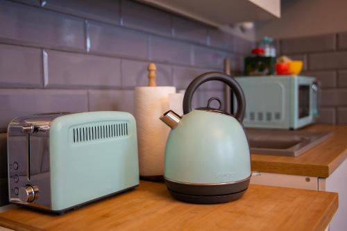 a kitchen counter with a tea kettle and a toaster at Apartament u Olechny in Bydgoszcz