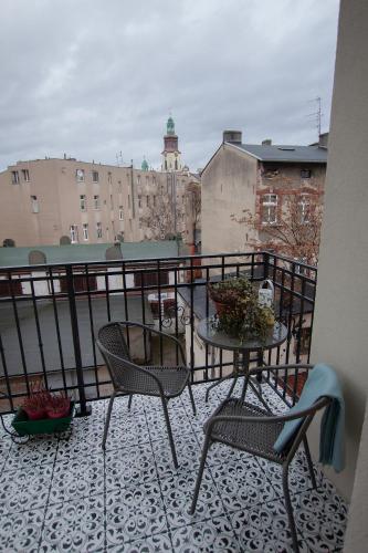 a balcony with two chairs and a table on a balcony at Apartament u Olechny in Bydgoszcz