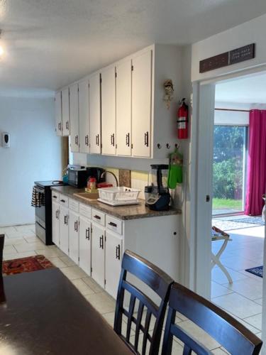 a kitchen with white cabinets and a table and chairs at AMOuR AMOUR in Southampton