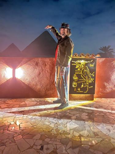 een man staat voor een muur bij El Khalil Pyramids Inn in Caïro