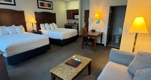 Best Western PLUS Hannaford Inn & Suites في سينسيناتي: غرفة فندقية بسريرين واريكة
