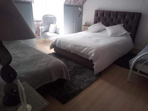 a bedroom with a large bed and a chair at Le Chalange in Lapenty