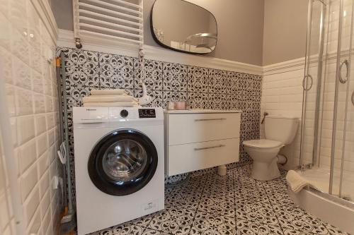 a bathroom with a washing machine and a toilet at Apartament u Olechny in Bydgoszcz