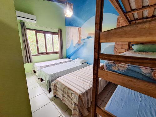 a room with three bunk beds and a window at Hostel Alto Astral - Lagoa in Morro de São Paulo