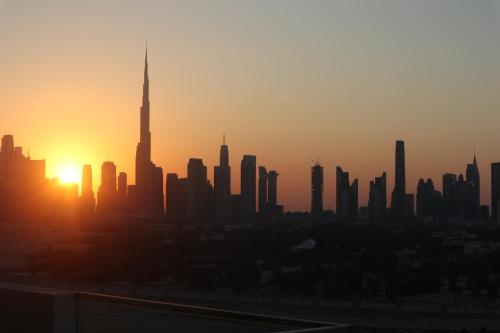 a city skyline at sunset with the tallest building at 1 Bedroom in a 2 Bed Apartment BURJ Khalifa View Ensuite King Bedroom Dubai Mall 8mins in Dubai