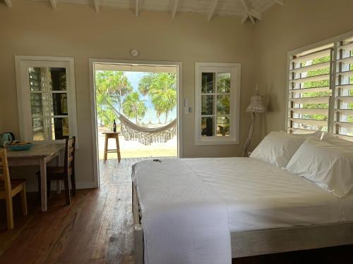 a bedroom with a bed and a dining room with a table at Belizima Eco Resort in Sarteneja