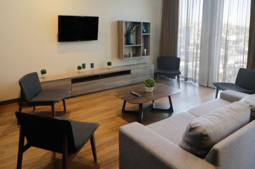 a living room with a couch and a tv at City Express Suites by Marriott Tijuana Rio in Tijuana